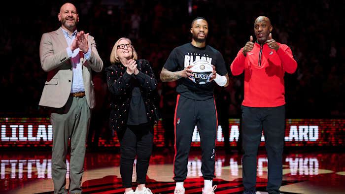 Portland Trail Blazers GM Joe Cronin, left, owner Jody Allen, and head coach Chauncey Billups stand with guard Damian Lillard (0) as he is congratulated on making the NBA All Star team.